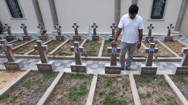 A katuvapitijai Szent Sebestyén-templom elleni támadásban elhunyt családtagjainak sírjai előtt áll egy gyászoló 2020. április 21-én, a Srí Lanka-i húsvéti merényletek első évfordulóján