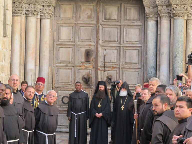 Ünnepélyes bevonulás előtt a Szent Sír-bazilika kapujában: középen mindig a görög, jobbján a latin, balján az örmény képviselő