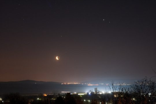 A felvételt Ábrahám Tamás készítette Zsámbékon 2020. március 19-én hajnalban. A holdsarló fölött a Mars, jobbra fent a Jupiter és a Szaturnusz látható.
